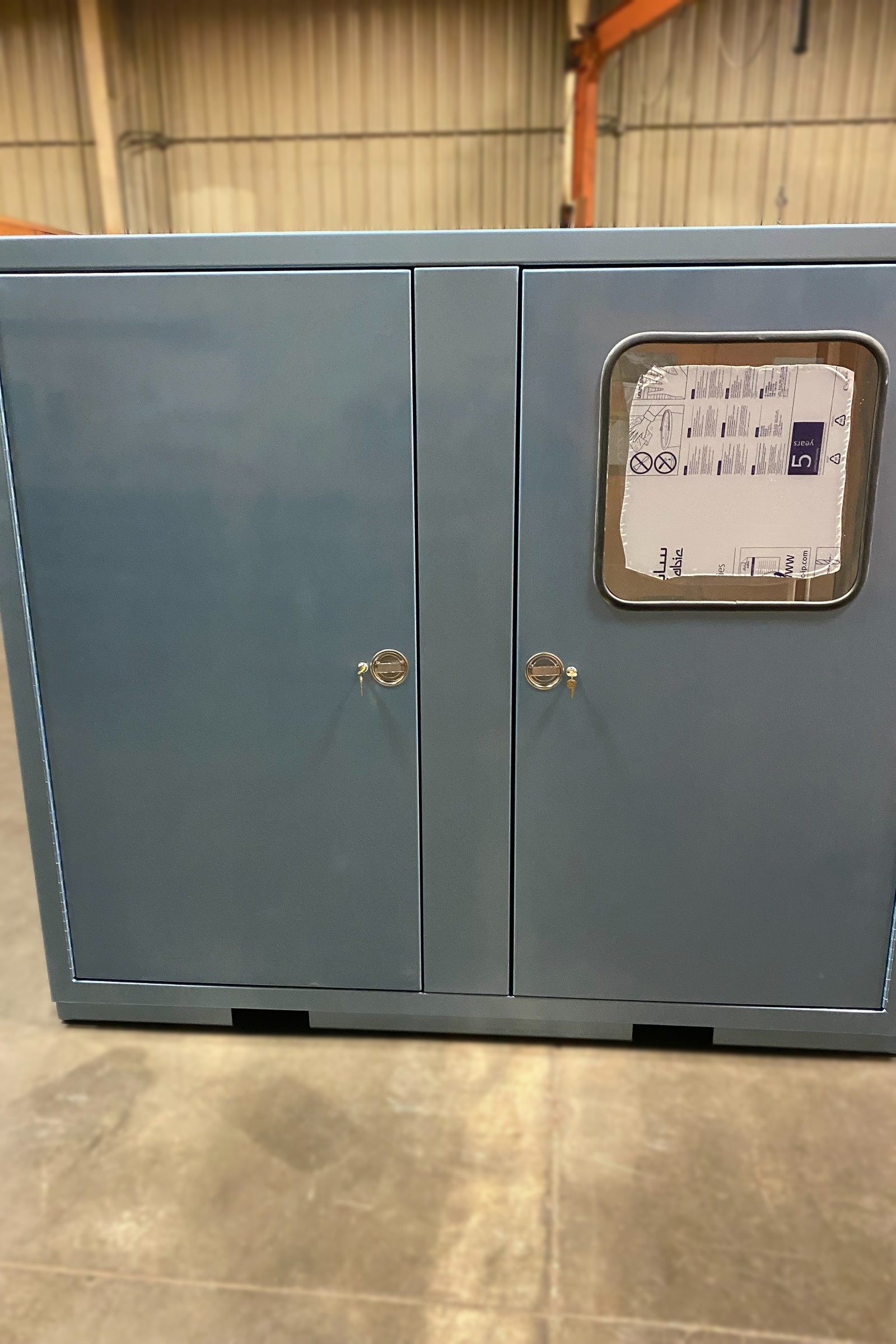 Fabricated control cabinet with a window cutout and punched openings.