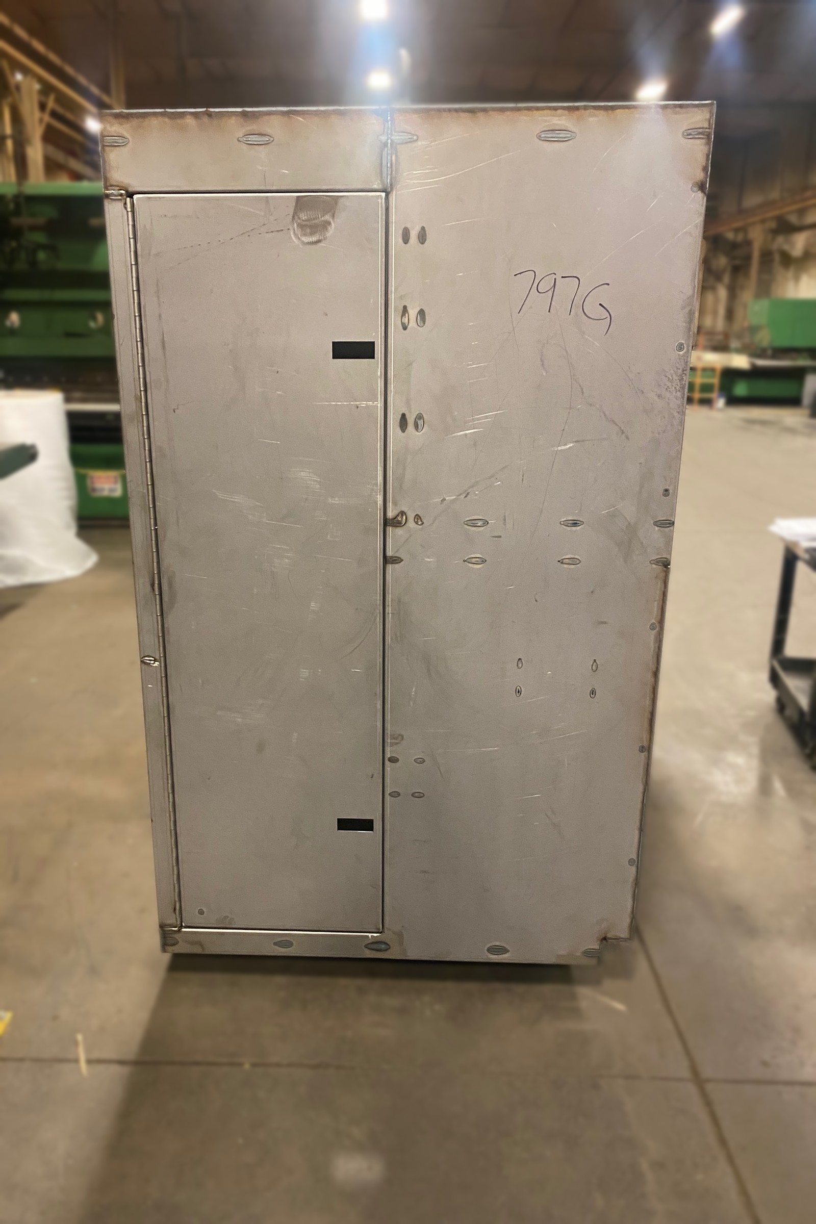 Unfinished metal double-door cabinet in the shop.