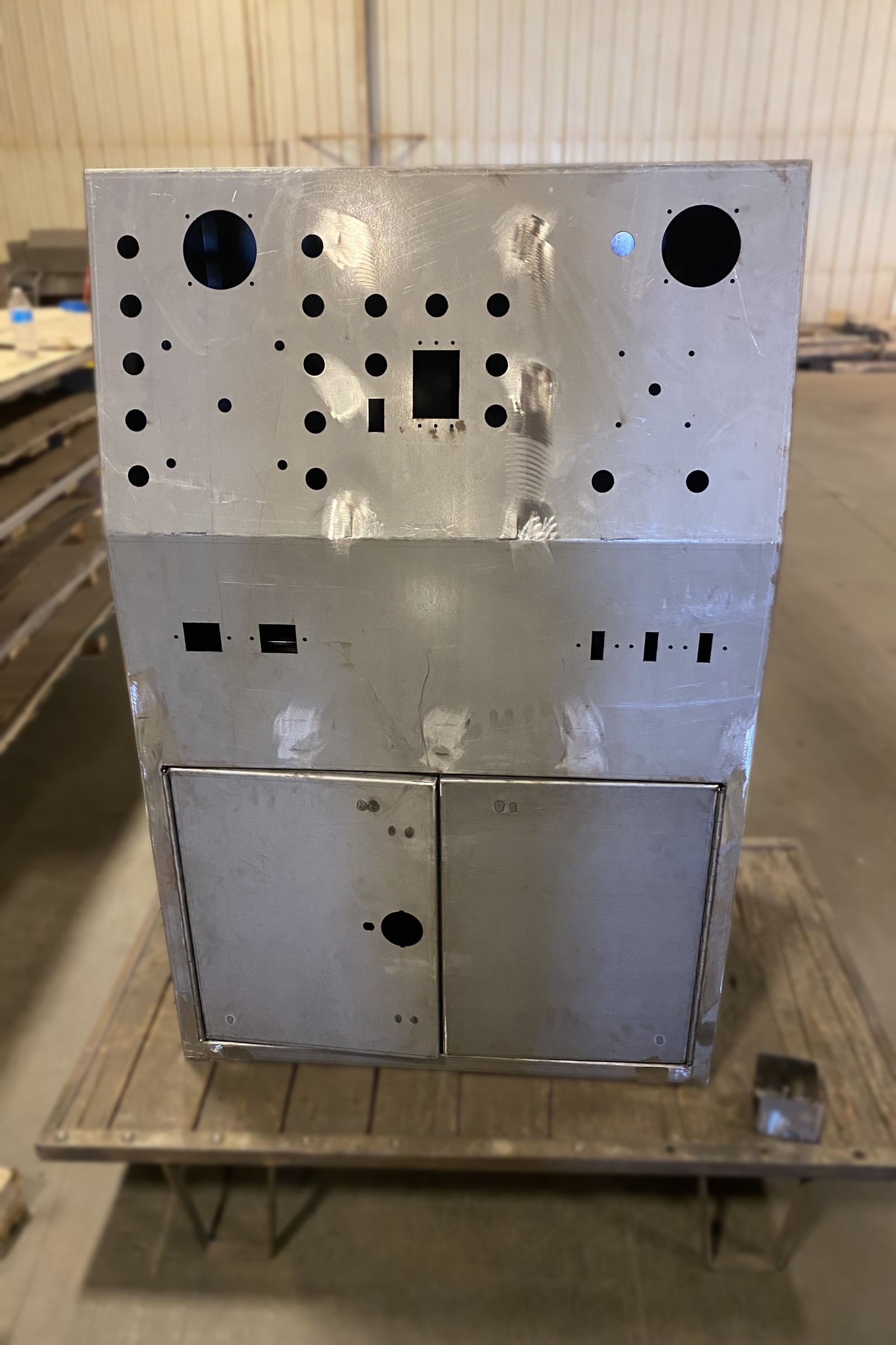 Metal console panel with a dense pattern of punched openings.