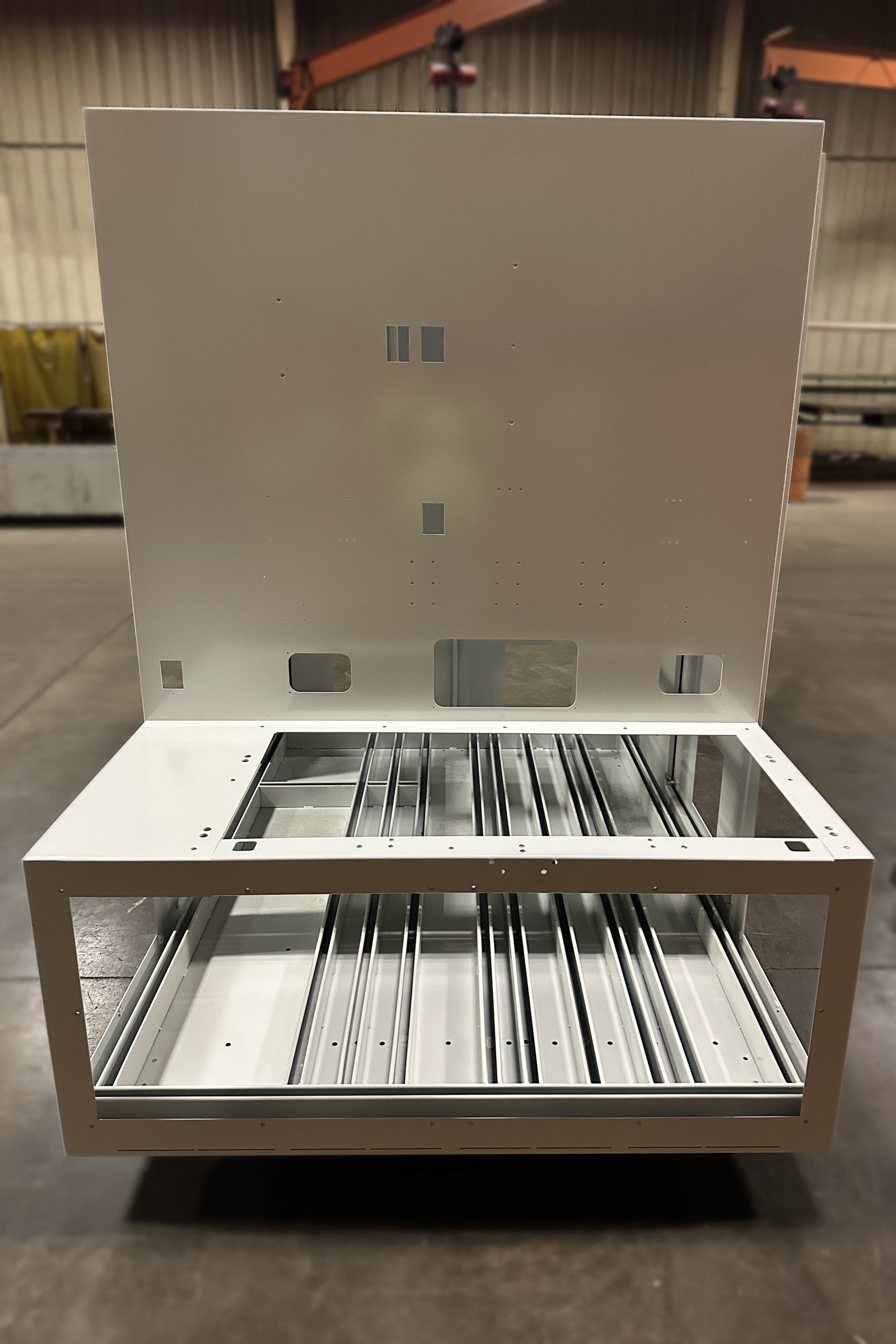 Painted enclosure opened to show an internal rail assembly in the base.