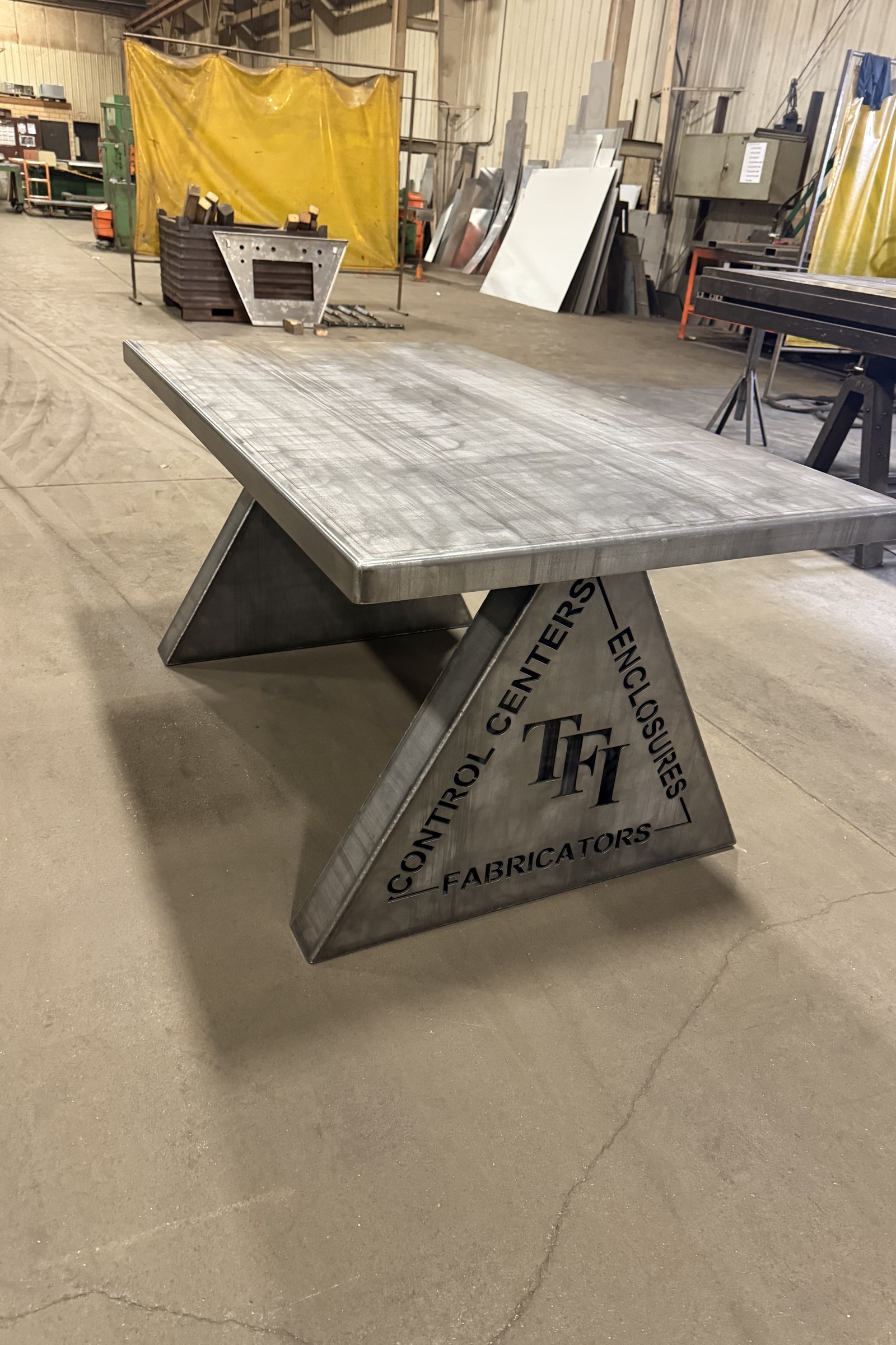 Custom fabricated metal table assembly with welded support structure.