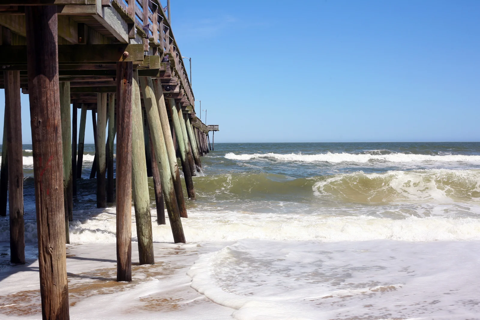 Surf rolling beneath the Virginia Beach Fishing Pier.