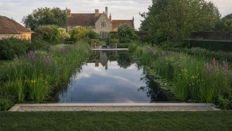 Swimming pond at dawn with an oak jetty over dark, still water