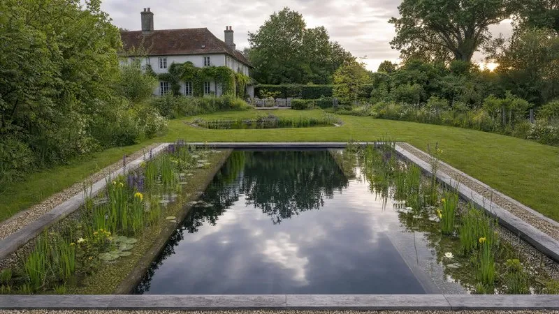 Natural pool beside a red brick house