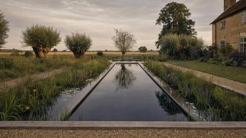 A wildlife pond edged with timber decking and native planting