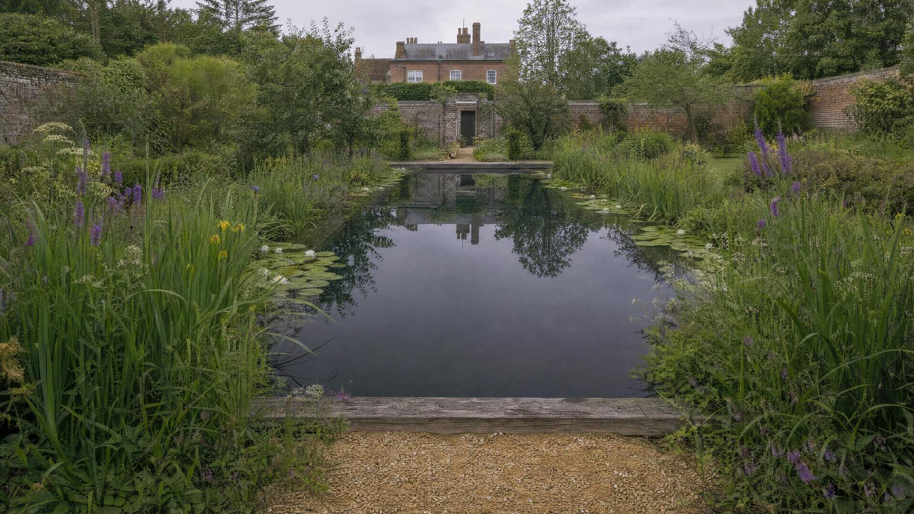Natural pool beside a red brick house