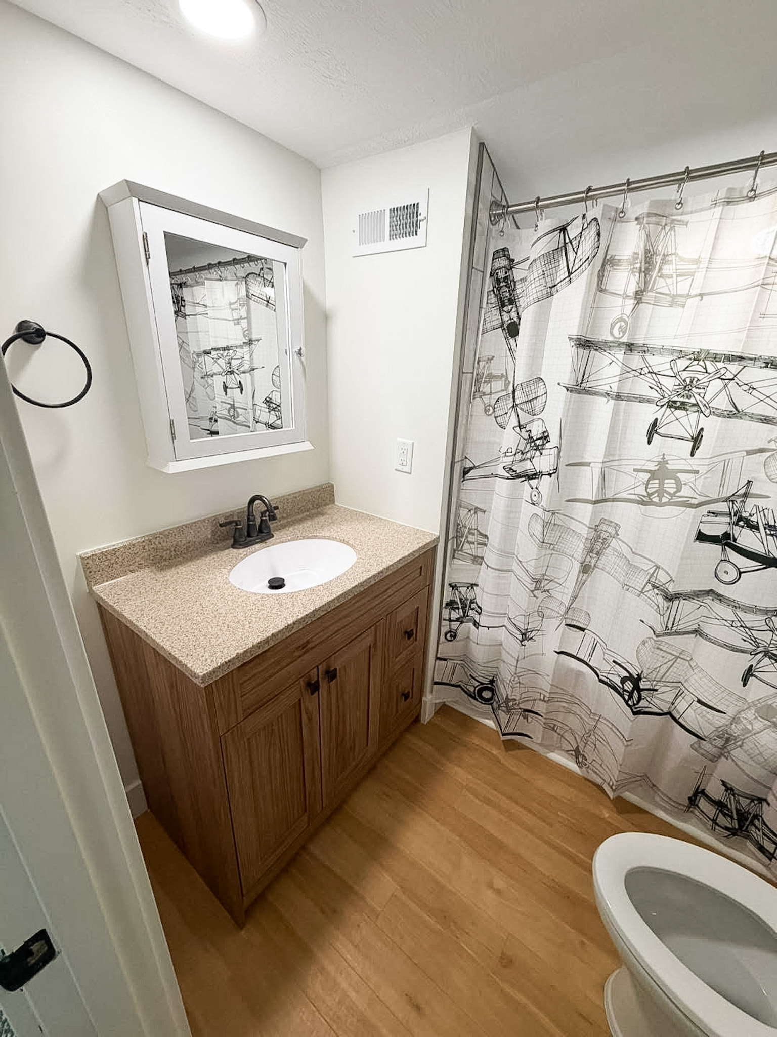 Updated bathroom with new wooden vanity and tub and surround shower