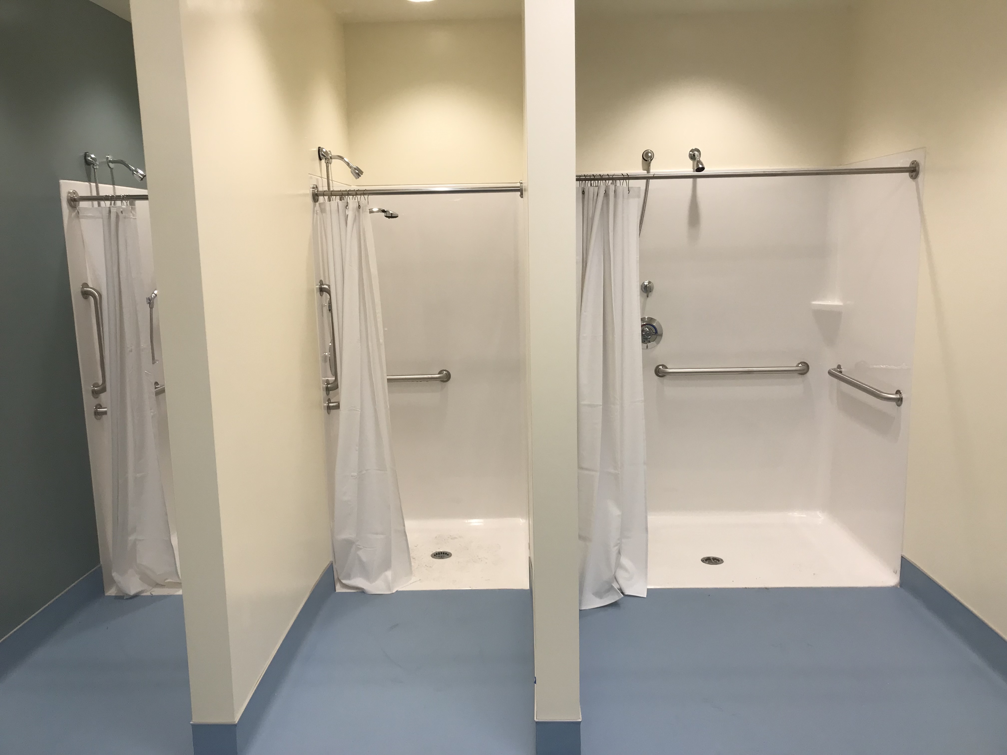 Commercial standing showers with curtain partitions