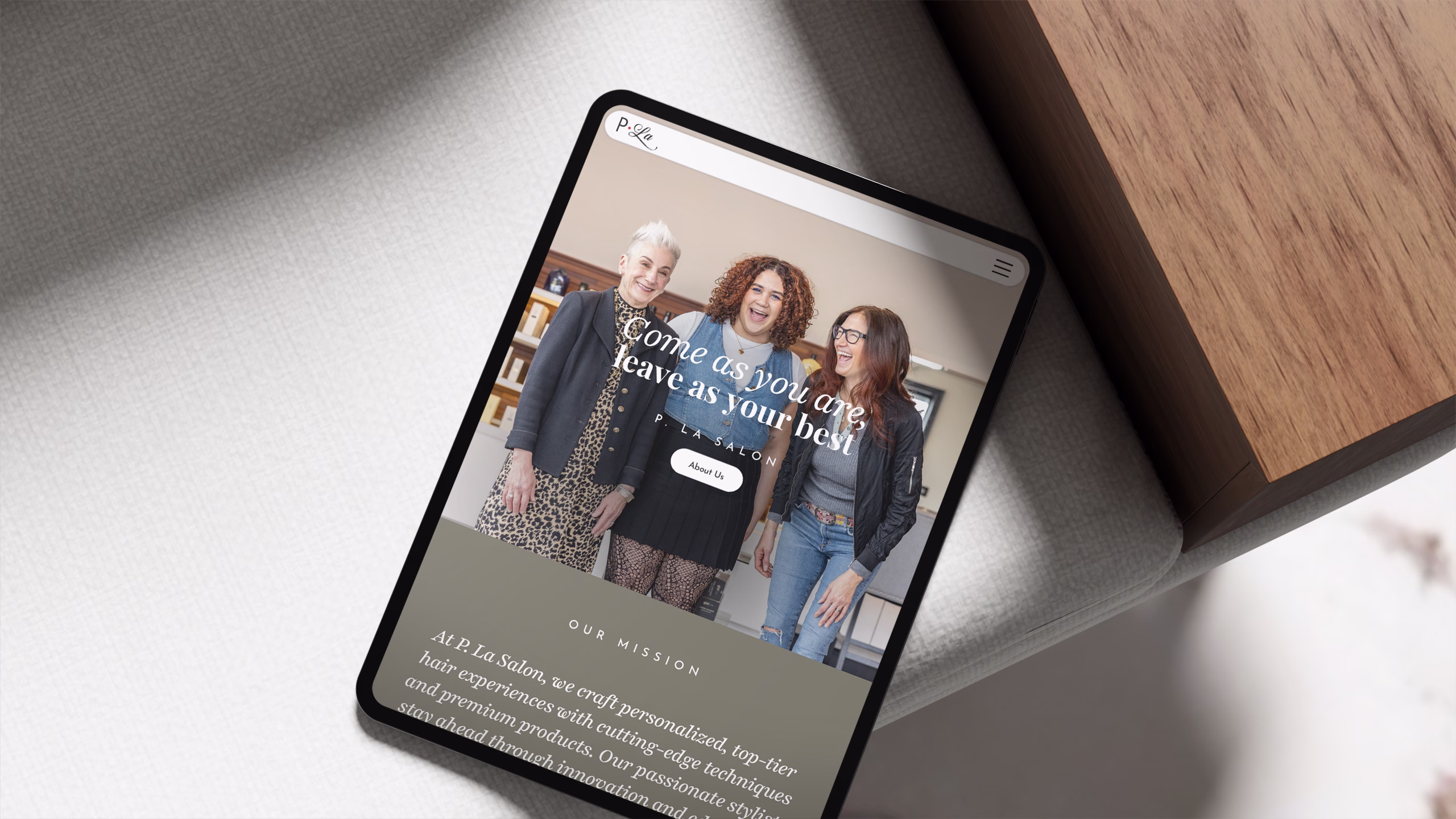 Tablet mockup of the P. La Salon homepage featuring three stylists and the tagline "Come as you are, leave as your best."