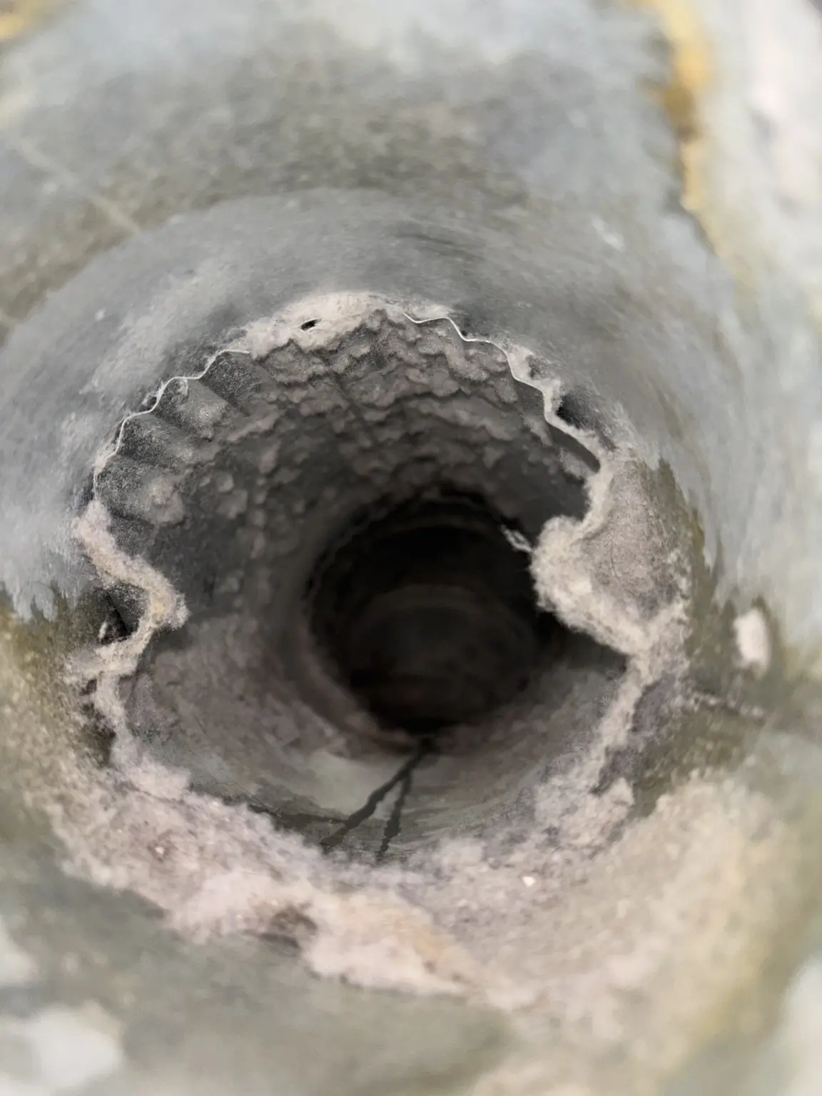 Close-up view of thick lint buildup restricting a dryer vent line.