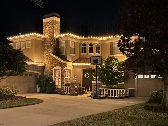 Luxury home with professionally installed warm white holiday lighting