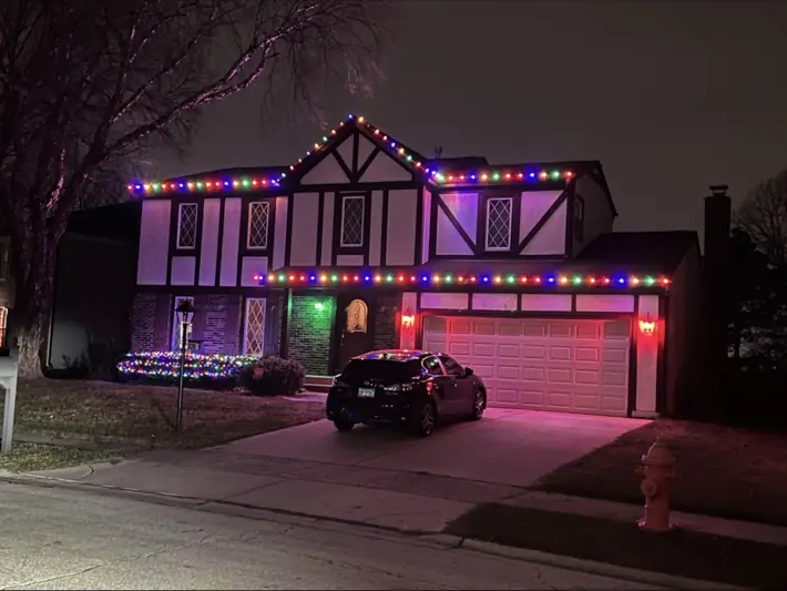 Home decorated with multicolor roofline holiday lights