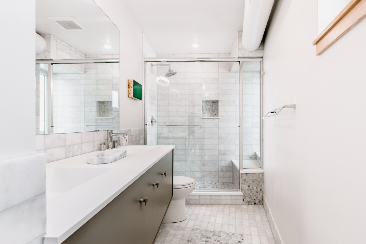 Bathroom with marble-look tile, glass shower and long floating vanity