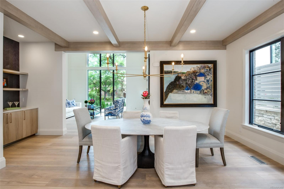 Dining room with white oak ceiling beams, round table and bar