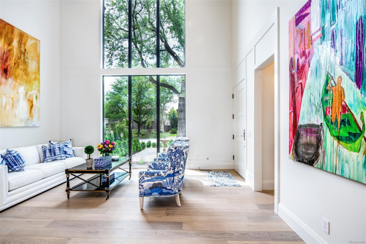 Living room with two-story windows and large-scale paintings