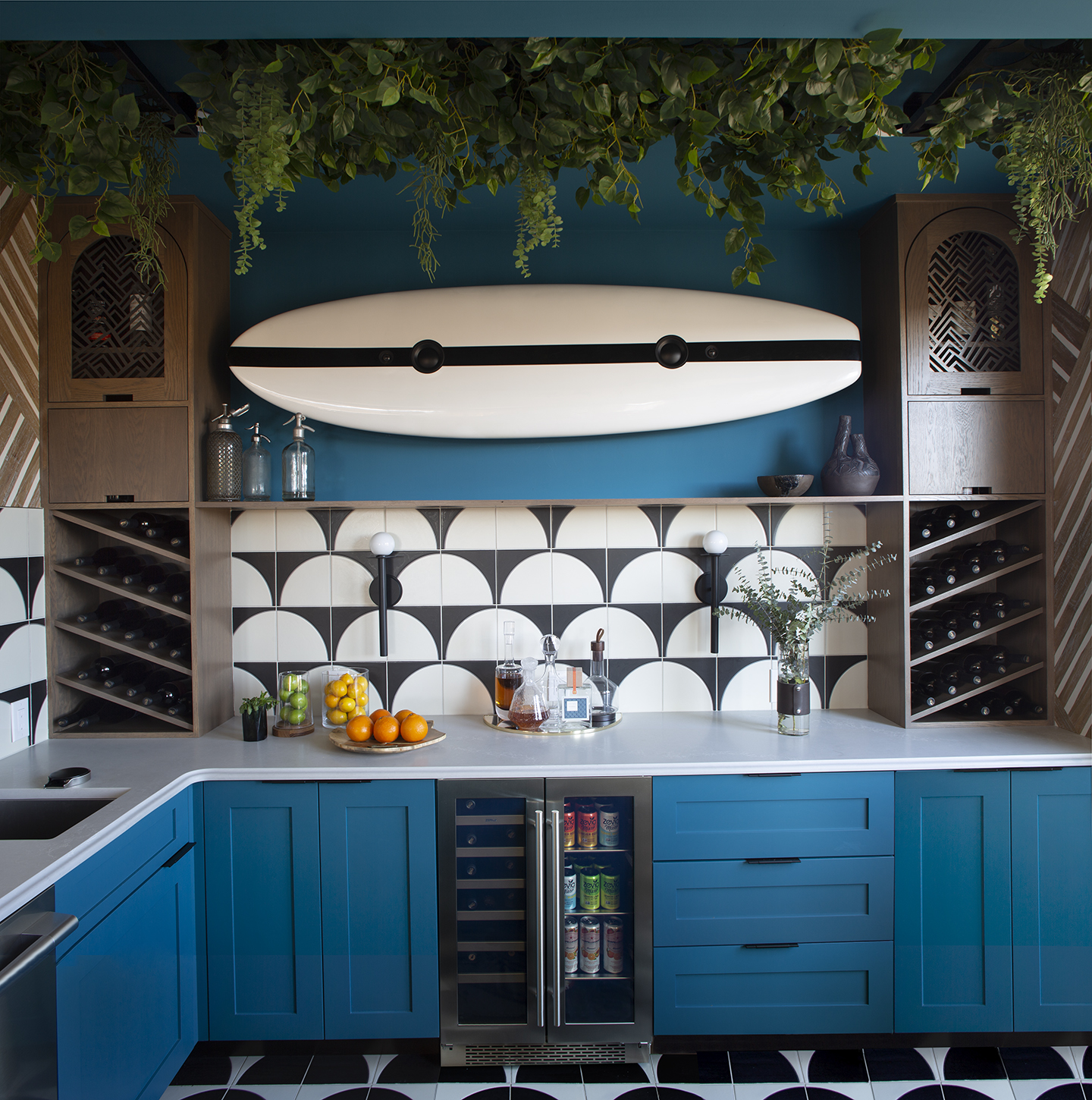 Bar with blue cabinetry, patterned tile backsplash, wine storage and a surfboard display