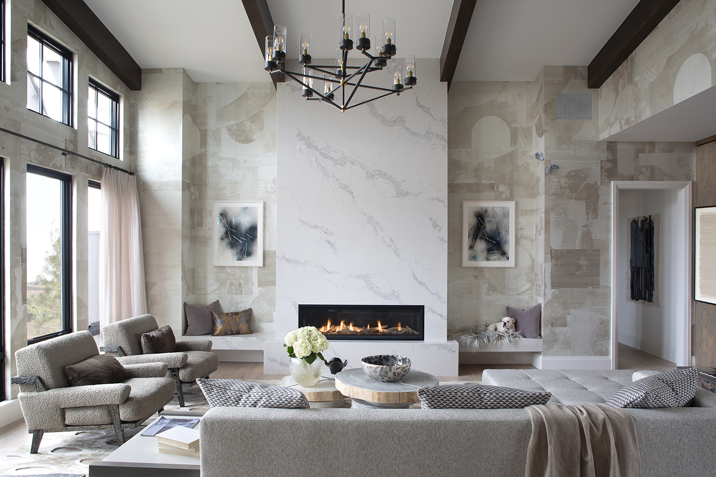 Great room with marble fireplace wall, beamed ceiling and gray sectional