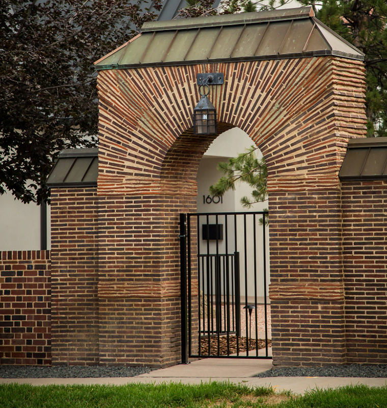 Brick archway and iron gate at a Cherry Creek home entry