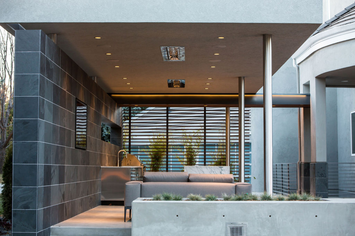 Covered outdoor lounge with slate tile wall, recessed lighting and horizontal slat screen