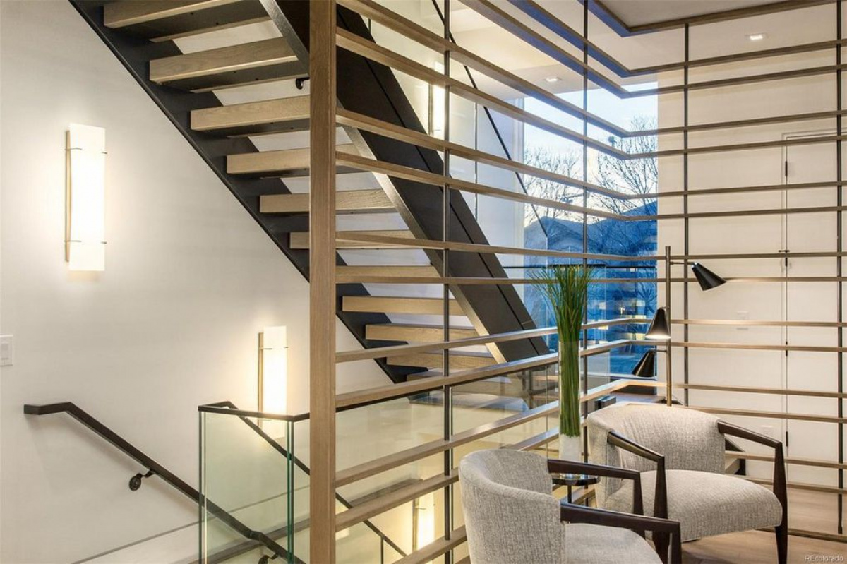 Floating staircase with steel slat railing beside a two-story window