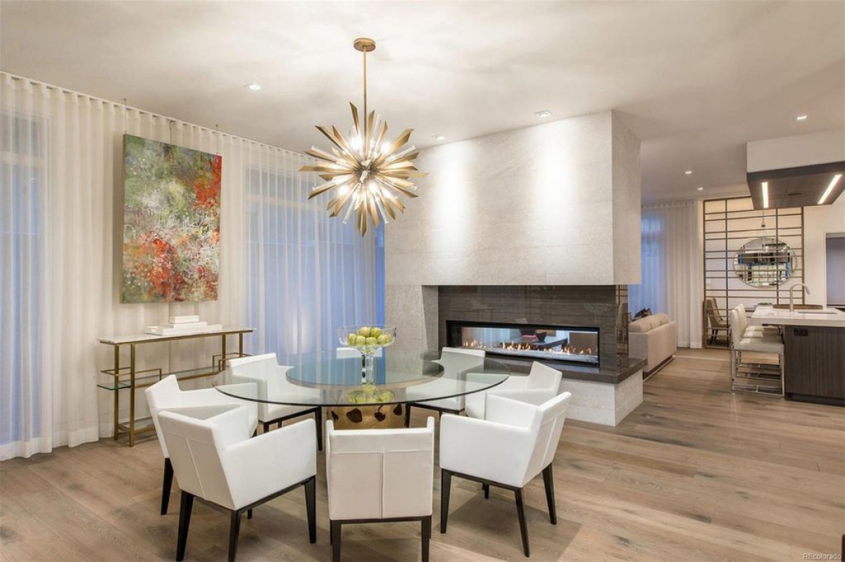 Dining room with sputnik chandelier and see-through linear fireplace