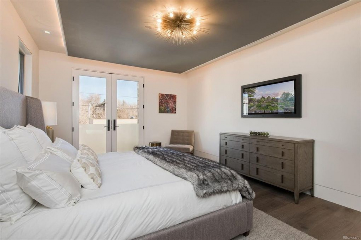 Bedroom with dark tray ceiling and French doors to a balcony