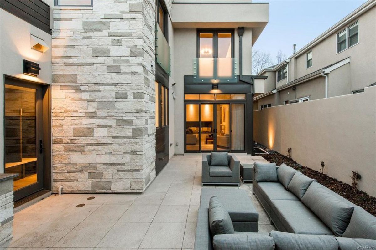 Stone-clad courtyard patio with sectional seating at dusk