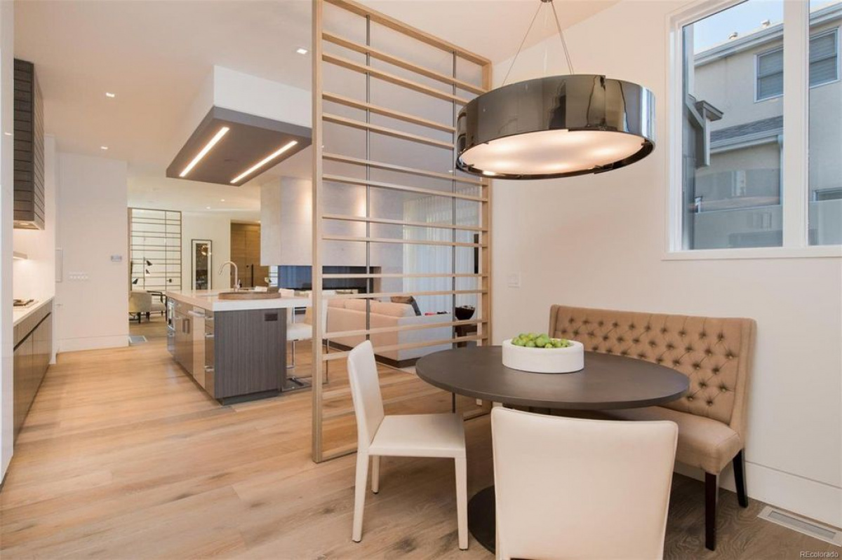 Breakfast nook with round table and tufted banquette beside the kitchen