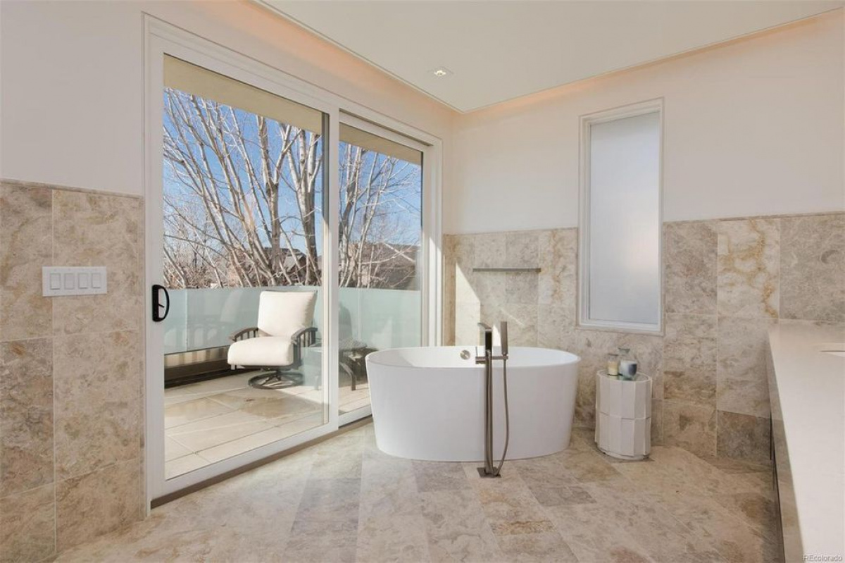 Bathroom with freestanding tub beside a balcony door
