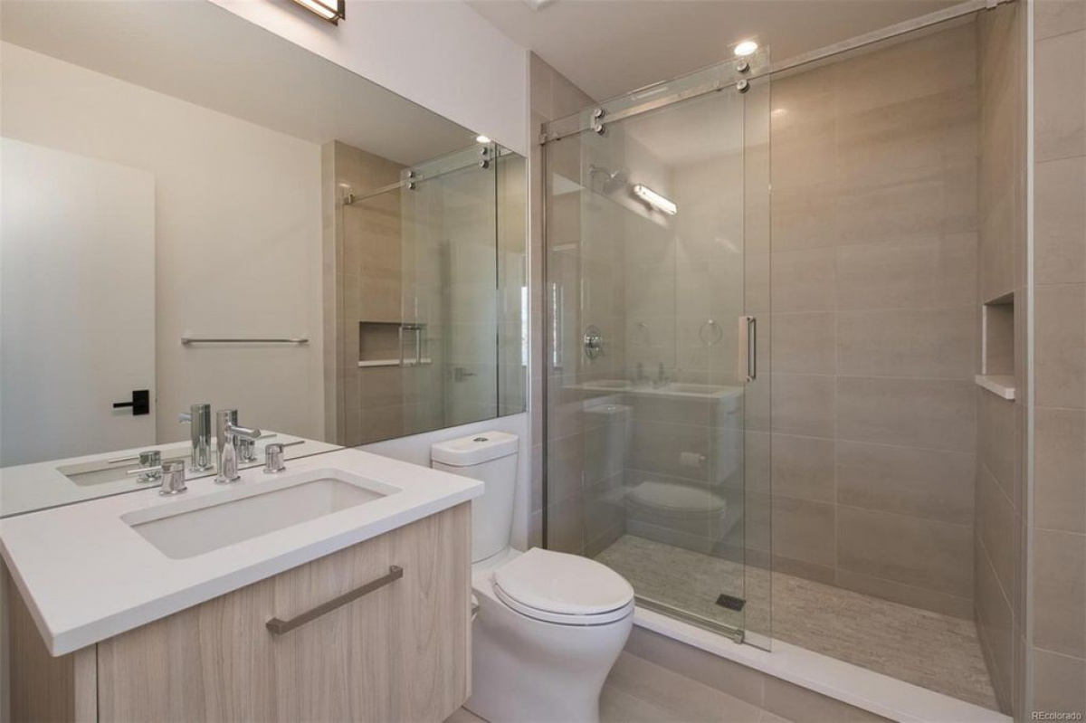 Guest bathroom with glass shower and light wood vanity