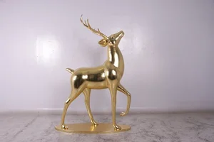 Shiny gold sculpture of a stag with antlers standing on a flat base.
