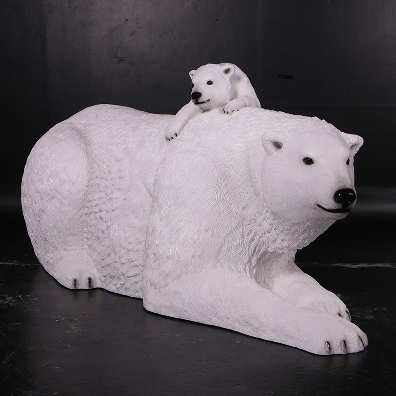 White polar bear sculpture lying down with a small polar bear cub resting on its back.