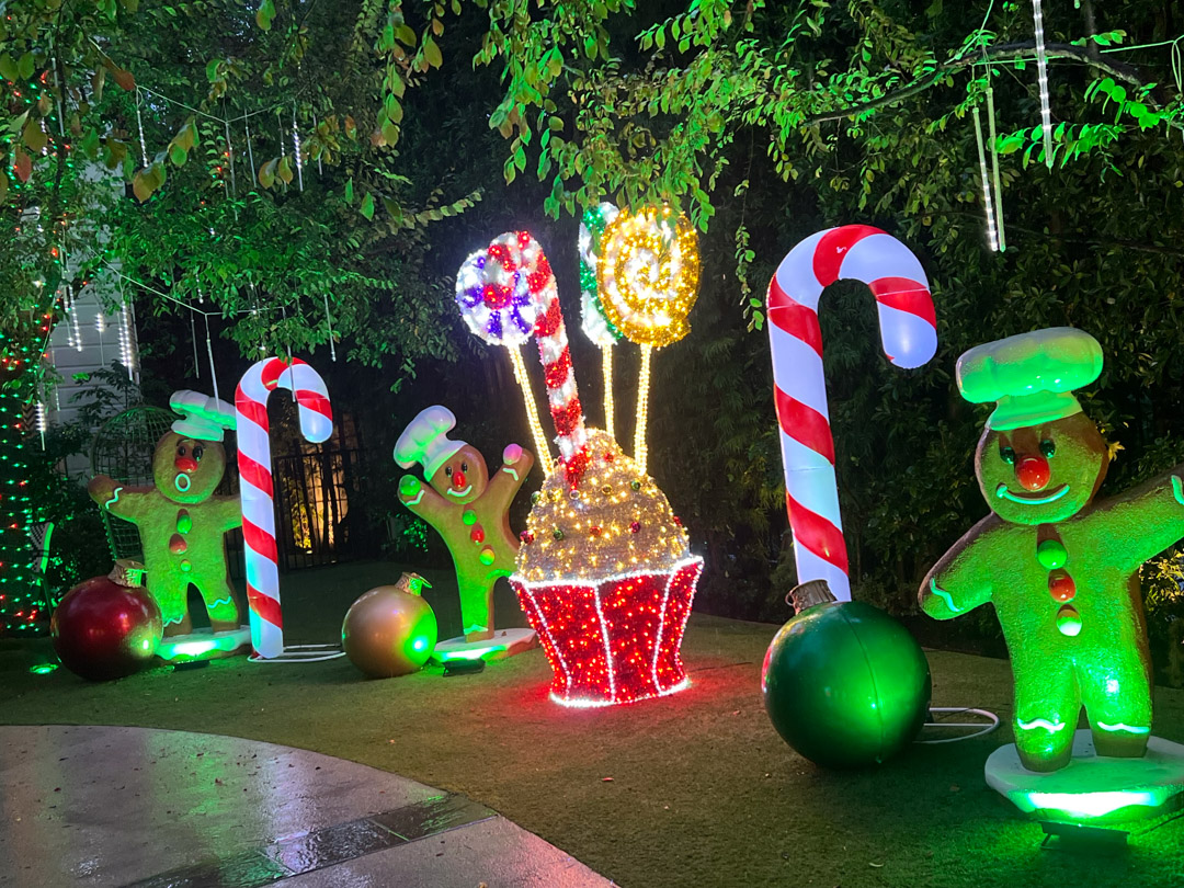 Christmas lights scene with a jumbo light up cupcake with lollipops, surrounded by three gingerbread men, and candy canes.
