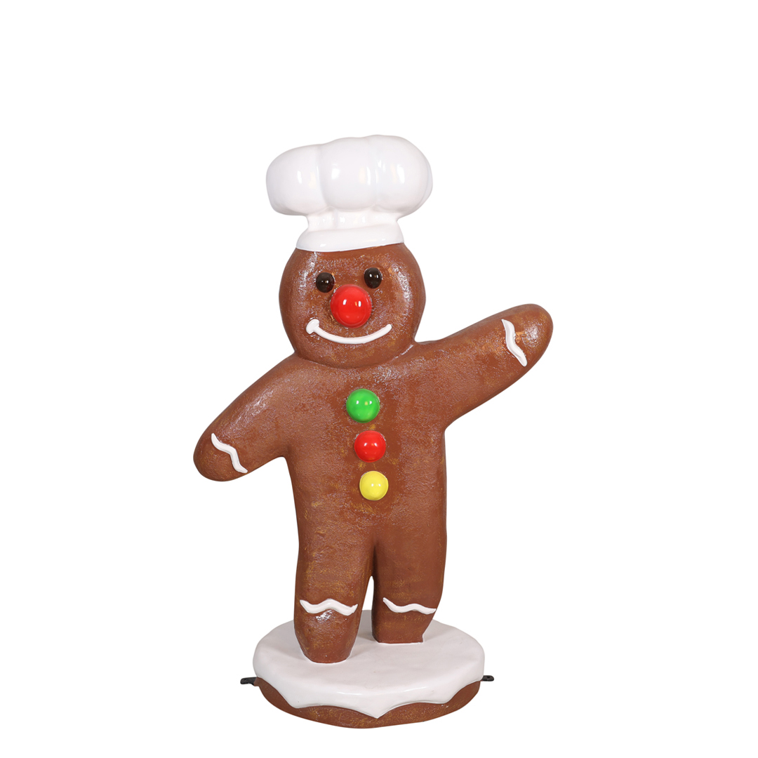 Gingerbread man figurine wearing a chef's hat, decorated with candy buttons and icing details.