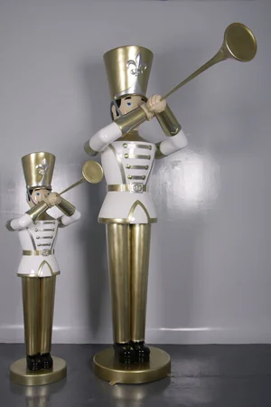Two decorative hornblower statues in white and gold uniforms playing long golden horns.