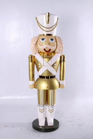 Gold and white nutcracker figurine with a mustache and white hat standing on a black base.