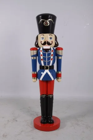 Tall wooden nutcracker soldier with blue uniform, red pants, and black tall hat on a red base.