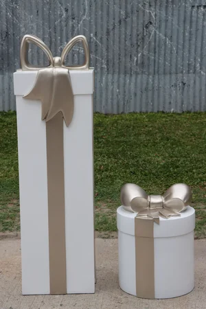 Two large white presents with gold bows, one tall rectangular and one small round.