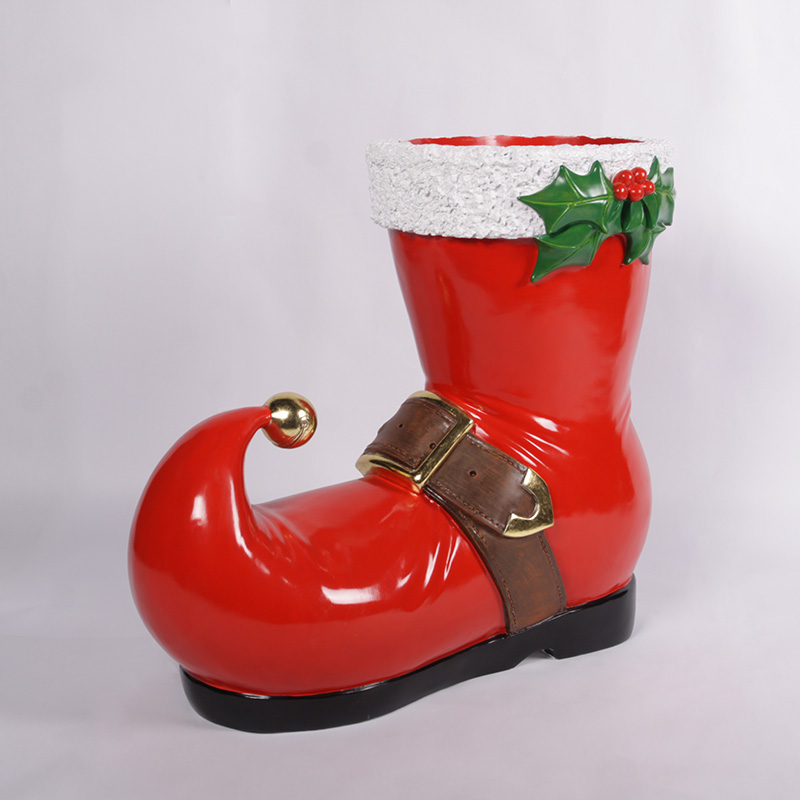 Shiny red Santa boot with a curled toe, brown belt, white cuff, and mistletoe decoration.
