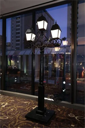 Black vintage-style three-lantern street lamp.