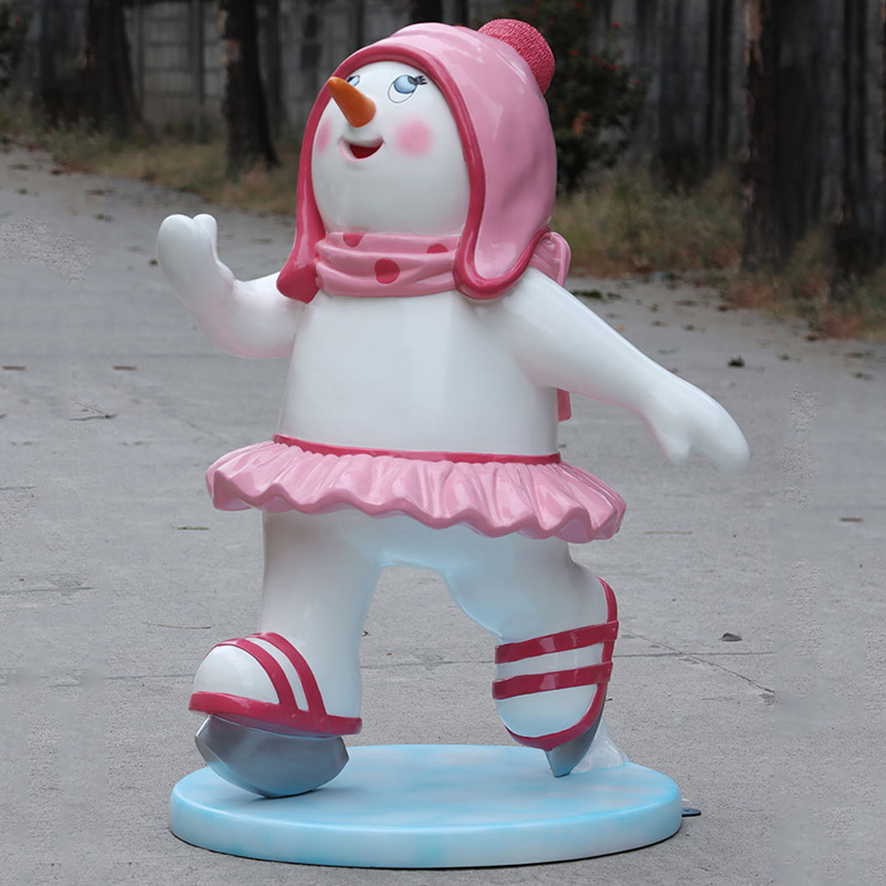 Snowman statue wearing a pink hat, scarf, and tutu with ice skates.