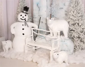 Snowman with top hat, white bench, and three polar bear decorations in snowy winter scene.