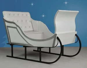 White vintage sleigh with cushioned seat and ornate runners against a blue background with stars.