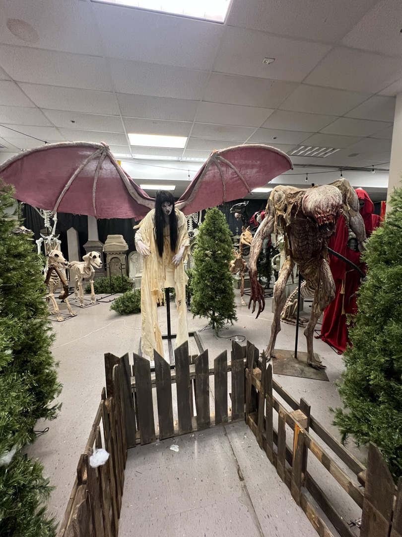 Indoor Halloween display with monstrous figure with large wings and a grotesque humanoid monster.
