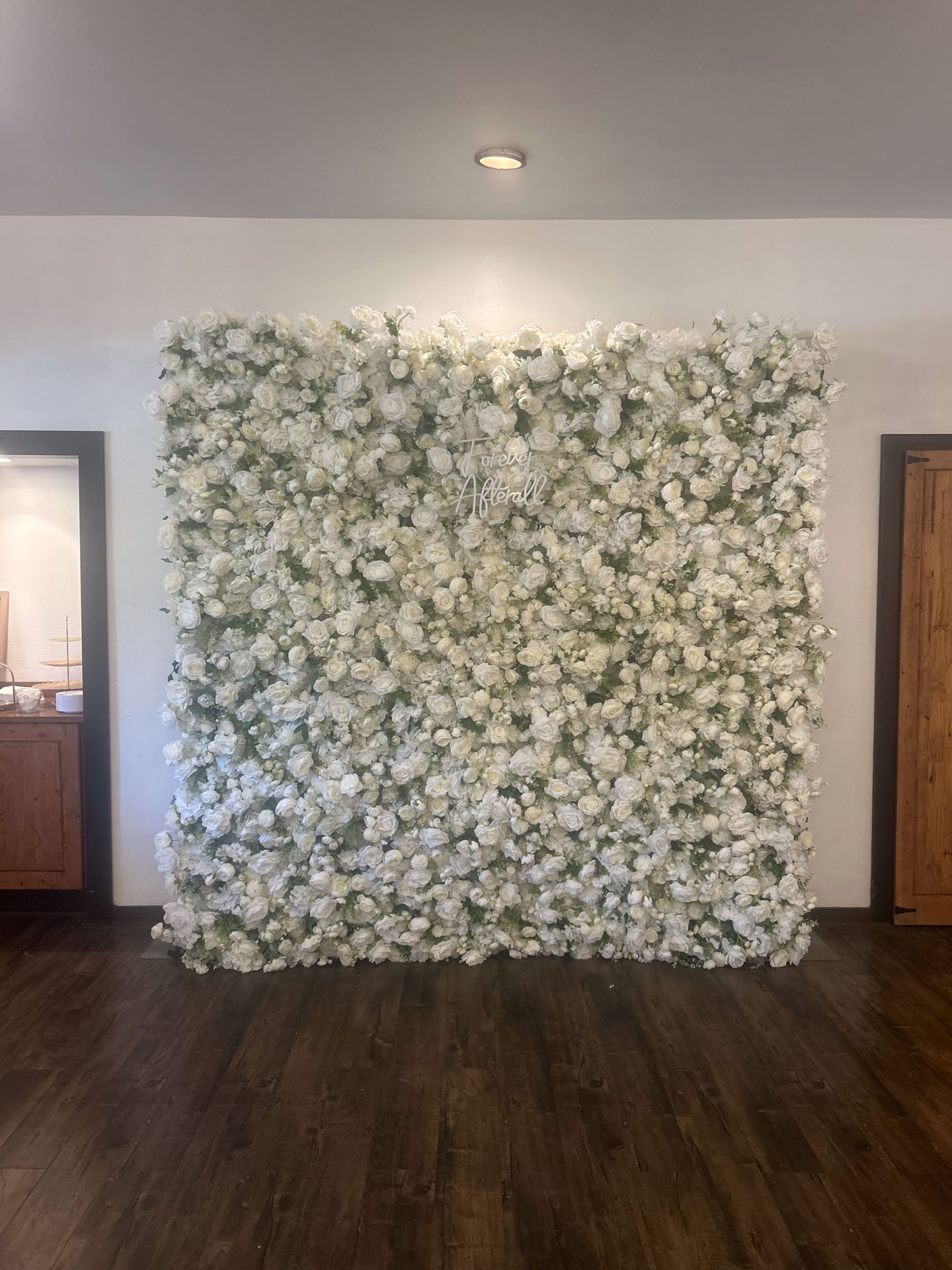 Wall backdrop covered in dense white roses.