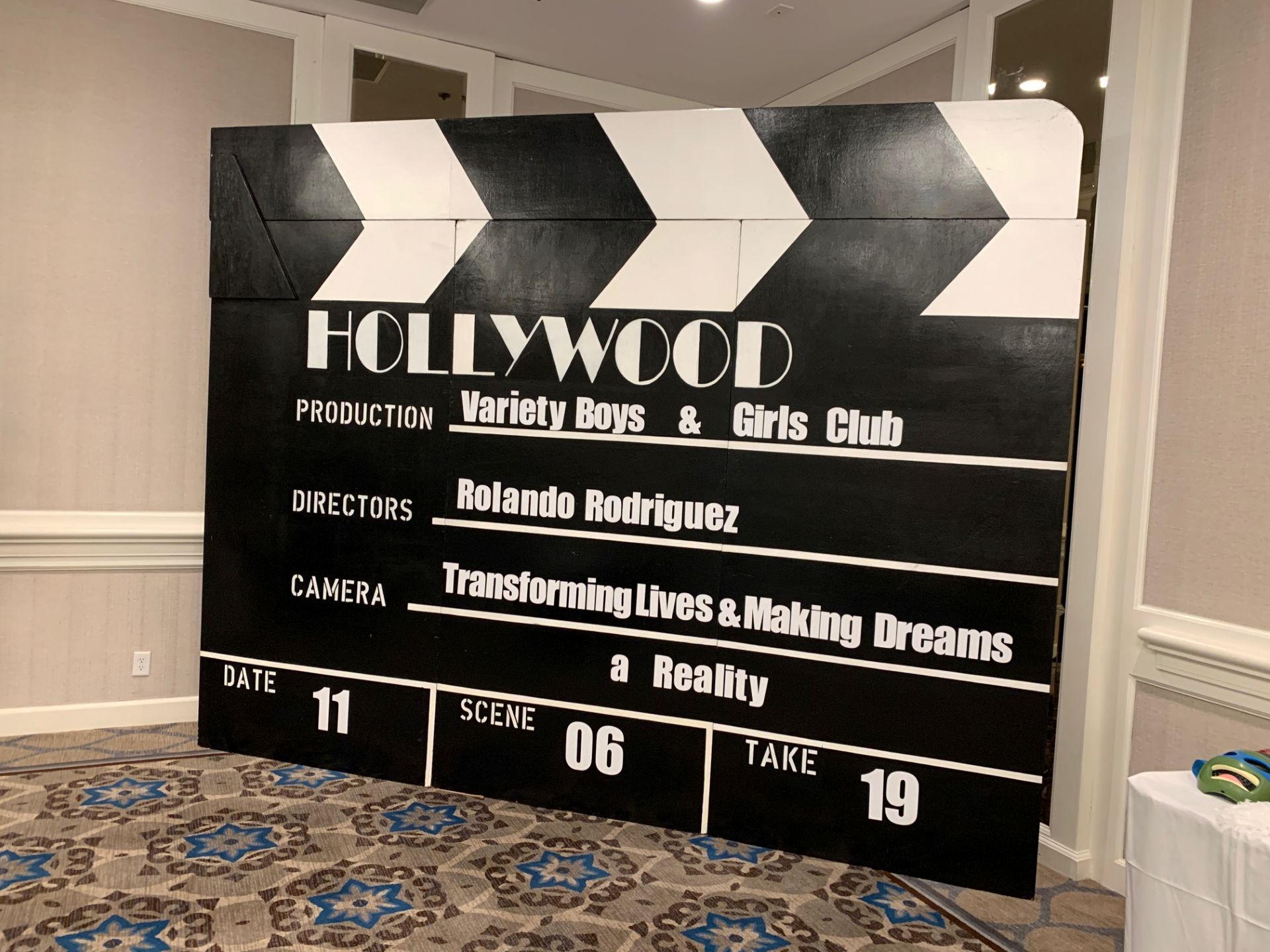 Large black Hollywood clapboard with white text.