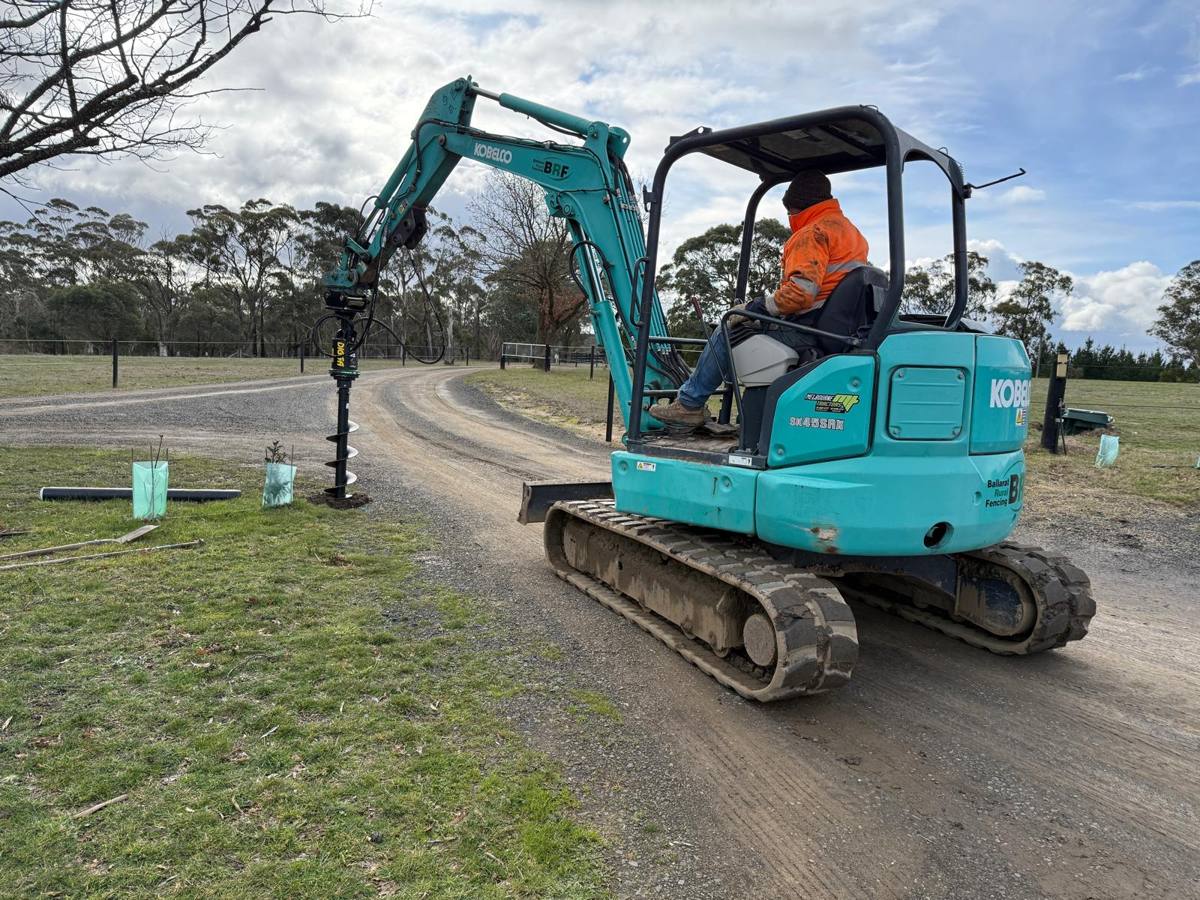 Woodshield bollard being installed with an excavator auger