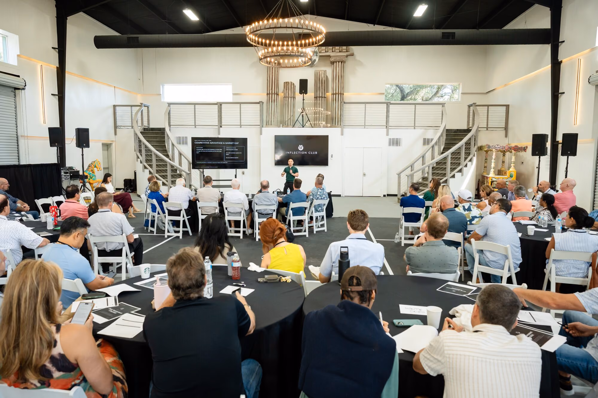 Round tables filling the main room during an Inflection Club session