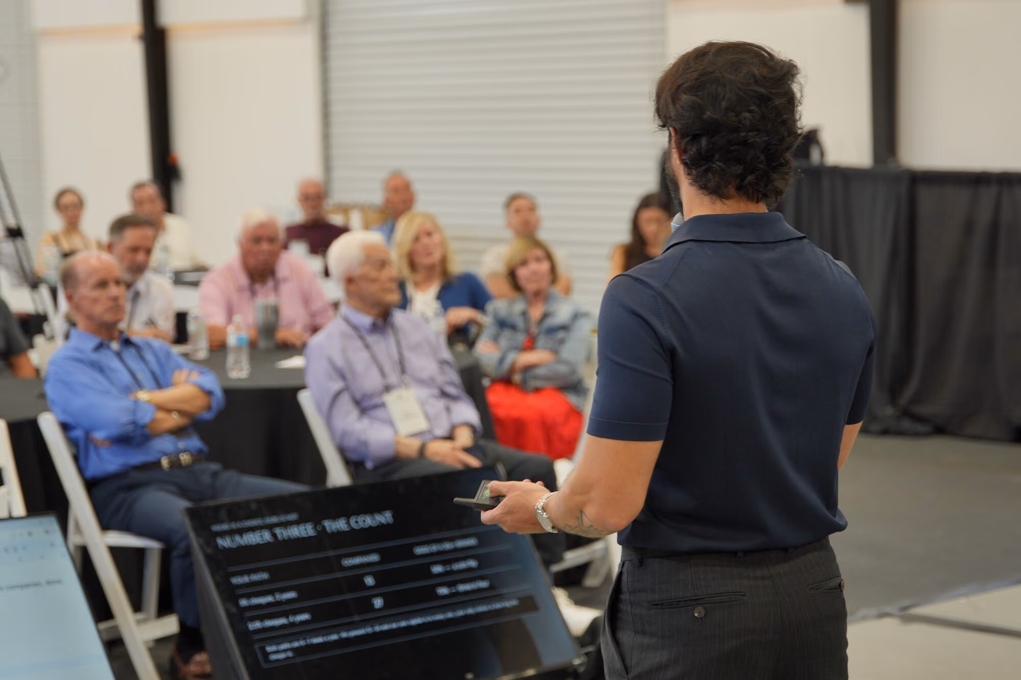 A host presenting to seated members during a session