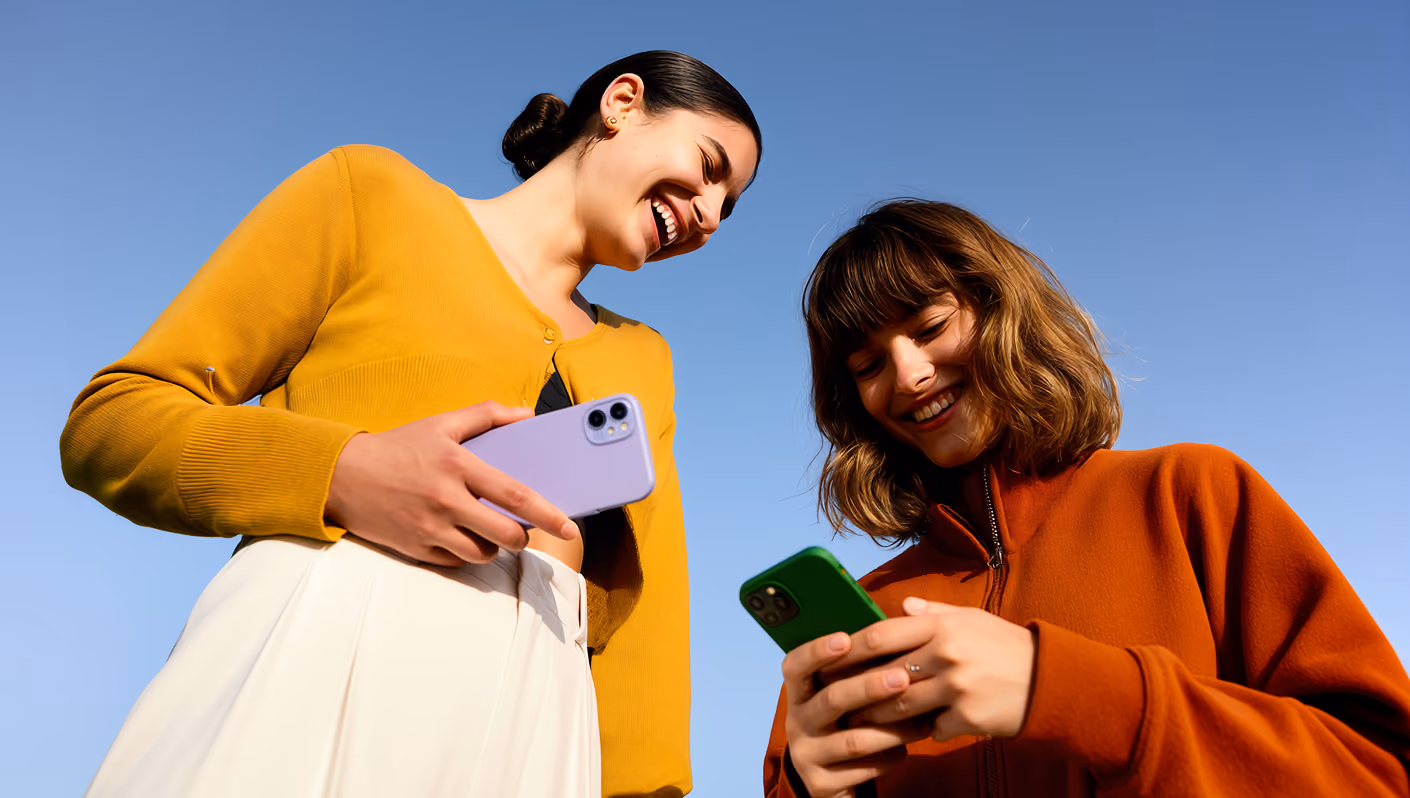 Two women outdoors holding phones